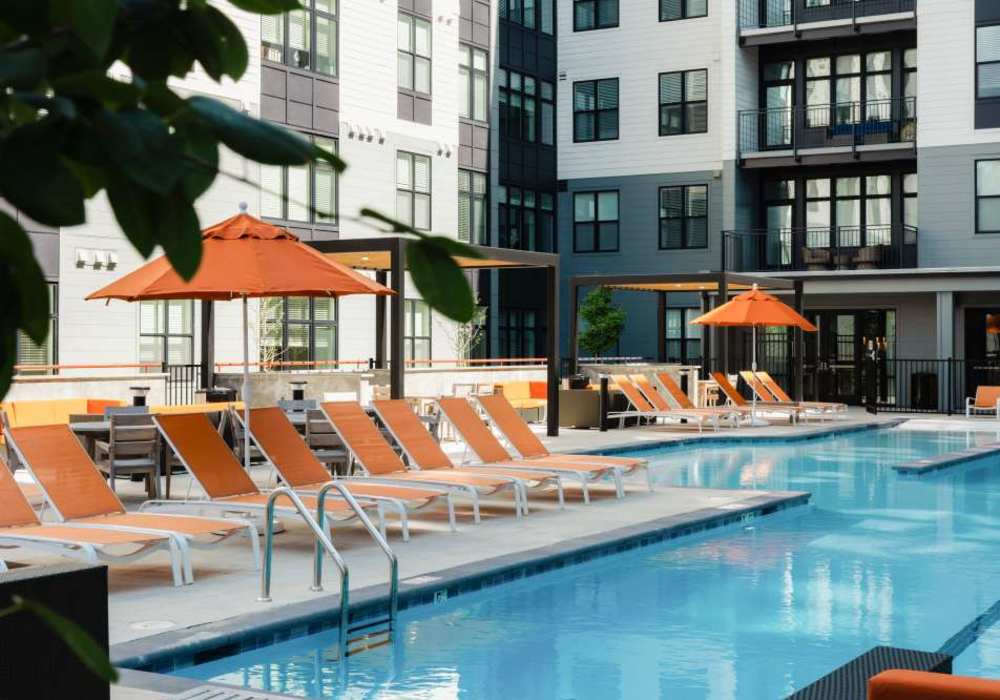 Swimming pool with lounge type seating and shades at The Maximilian at Stonefield in Charlottesville, Virginia