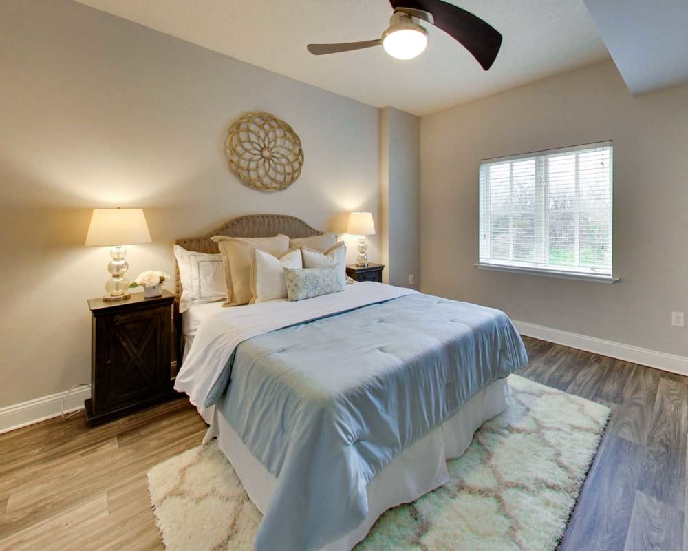 Model bedroom with ceiling fan and wood-style flooring at SouthPark Morrison in Charlotte, North Carolina