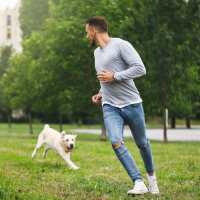 Resident playing with his dog in park near Lexington in The Woodlands, Texas