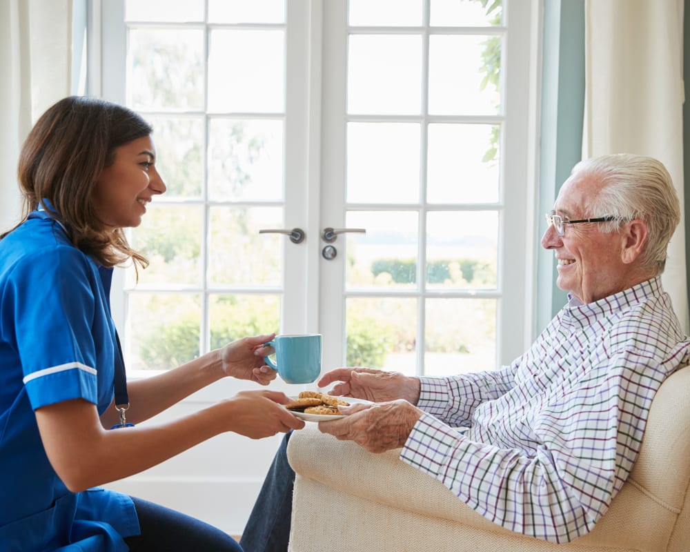 Staff brings assisted living resident a snack at Milestone Senior Living Faribault in Faribault, Minnesota.