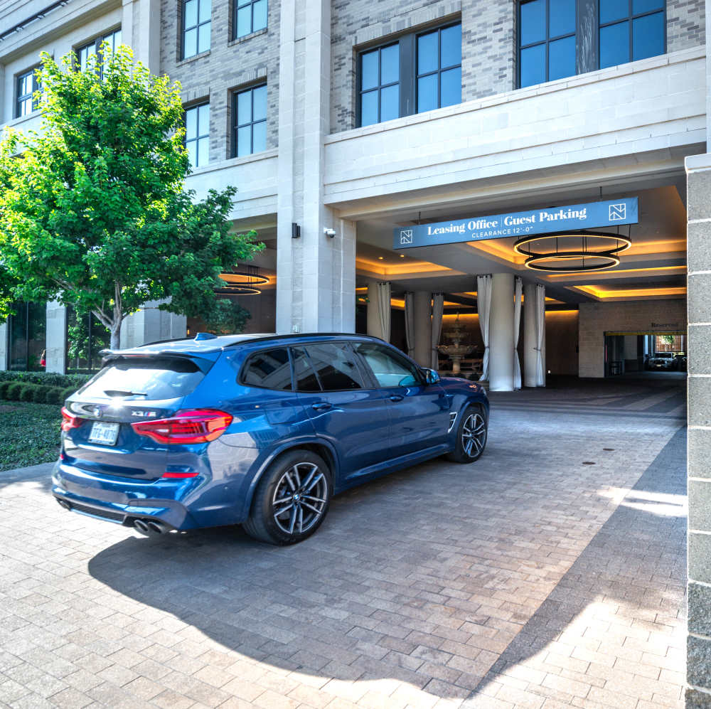 Modern leasing office entrance with lush greenery at Novel Turtle Creek in Dallas, Texas