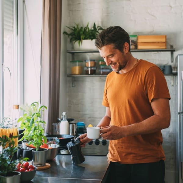 A resident makes coffee in his kitchen at Attain at Towne Centre, Fredericksburg, Virginia
