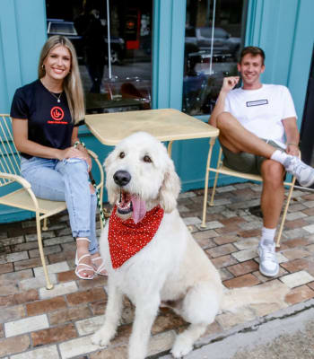 Students sit at table outdoors with their dog near University Lofts Downtown, Jonesboro, Arkansas