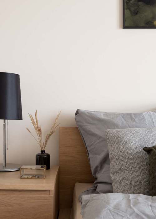 Cozy bedroom scene with a wooden nightstand at Textile Lofts at Planet Zero in Richmond, Virginia