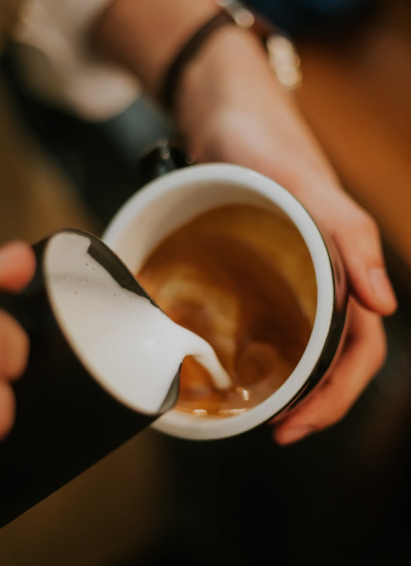 Barista pouring milk into latte in Tyler, Texas near Marquis at The Cascades