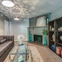 Relaxing living room with fireplace and glass table at London House Apartments in Lenexa, Kansas