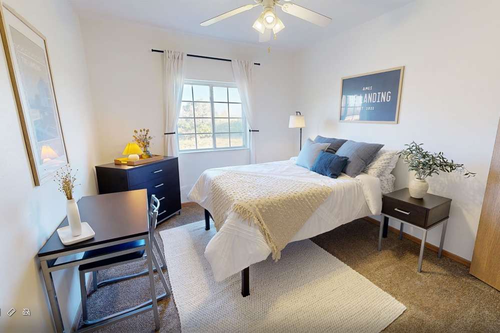 Apartment bedroom with desk and dresser at The Landing Ames in Ames, Iowa