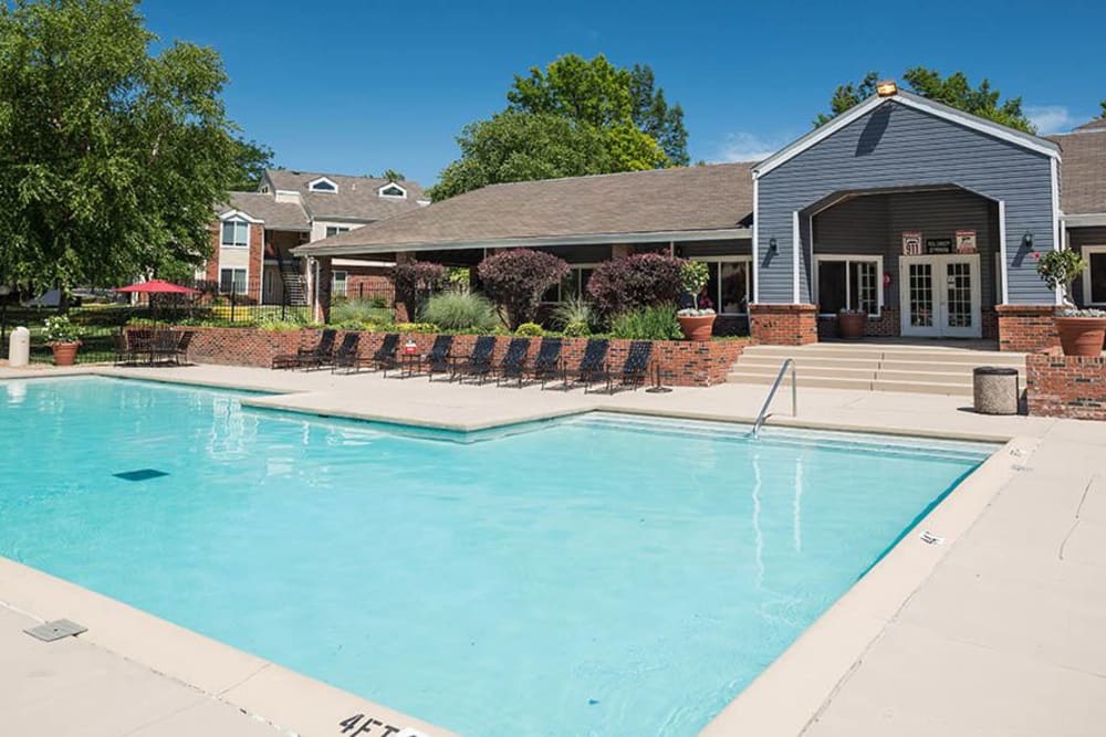 A swimming pool with a spacious sundeck for lounging at Sunbrook Apartments in Saint Charles, Missouri