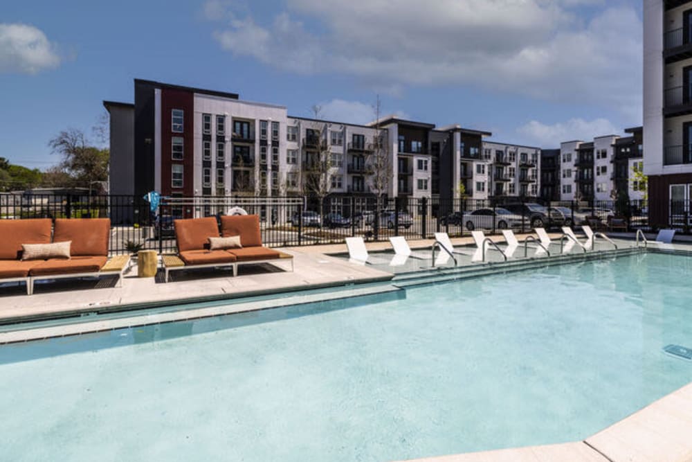 Swimming pool surrounded by cushioned seats and in-pool lounge chairs at Braxton Music City in Nashville, Tennessee