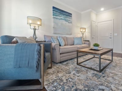 Living room of a model home with hardwood-style floors at Auberge of Burleson in Burleson, Texas