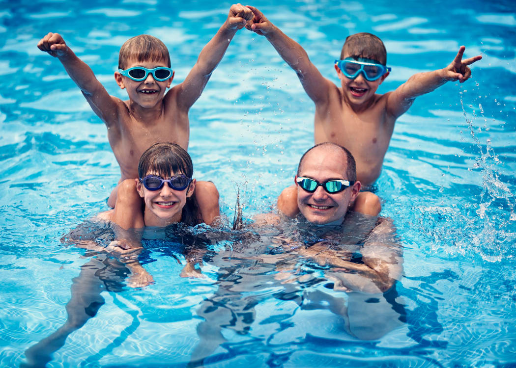 A family enjoying the refreshing swimming pool at Avilla Centerra Crossings in Goodyear, Arizona