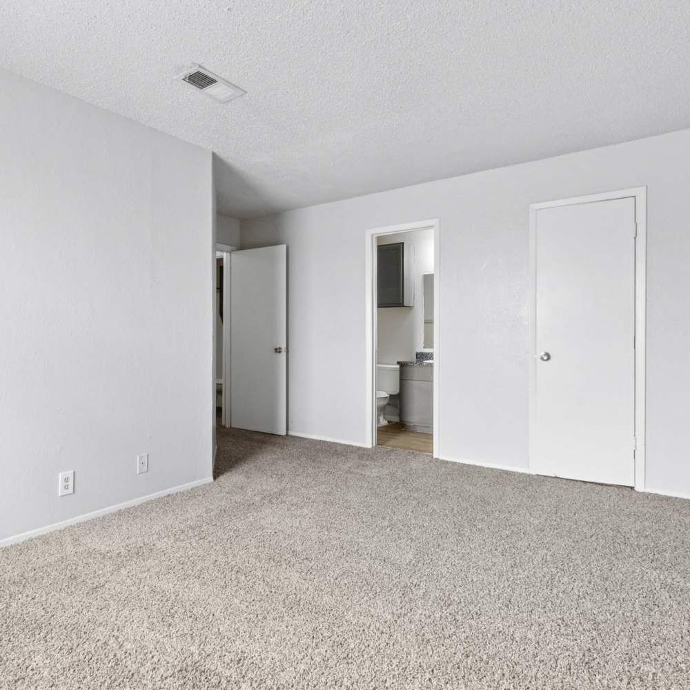 Cozy bedroom with carpet flooring at Arbors of Taylor in Taylor. TX