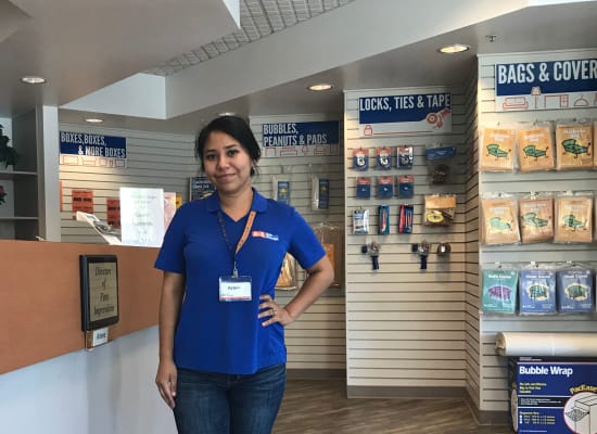 Staff member poses in front of packing and moving supplies available at A-1 Self Storage