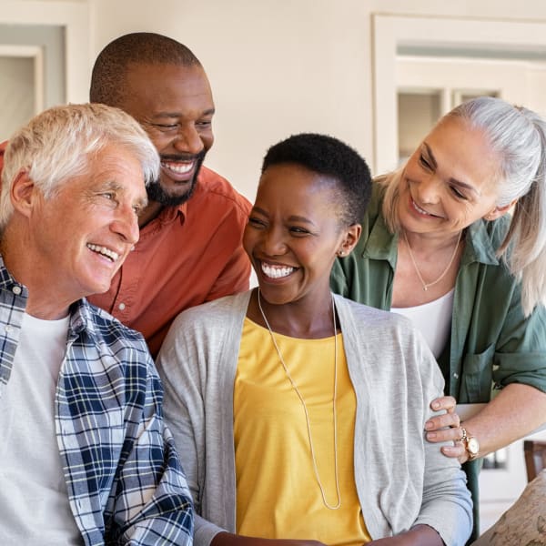 A group of residents outside smiling together at The Madison Senior Living in Kansas City, Missouri
