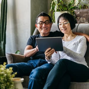 Couple sitting on a sofa in apartment at The Spring at Silverton in Fort Worth, Texas