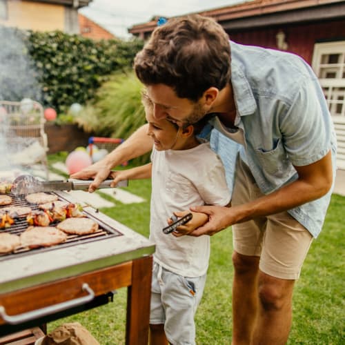 Father helping his child grill at Parc at Lyndhurst, Lyndhurst, New Jersey