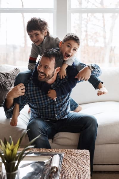 A family plays on the sofa in their apartment at Los Robles Apartments, Thousand Oaks, California