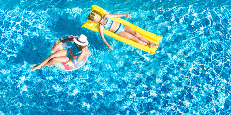 Residents relaxing on inflatable floats at a swimming pool at Reagan Park in Lemoore, California