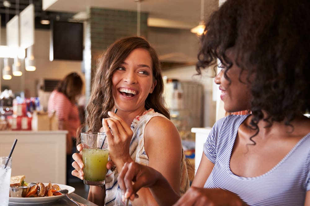 Residents enjoying drinks together at a restaurant near Cleo Luxury Apartments in Dallas, Texas 