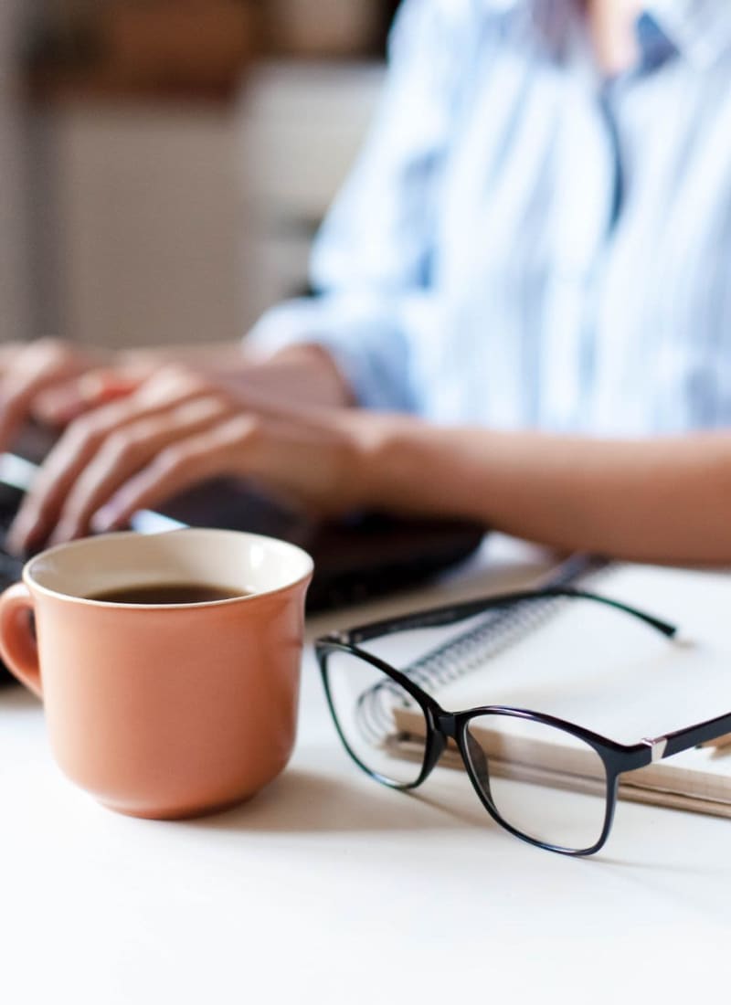 A resident on their laptop with coffee at Marquis Cross Mountain in San Antonio, Texas