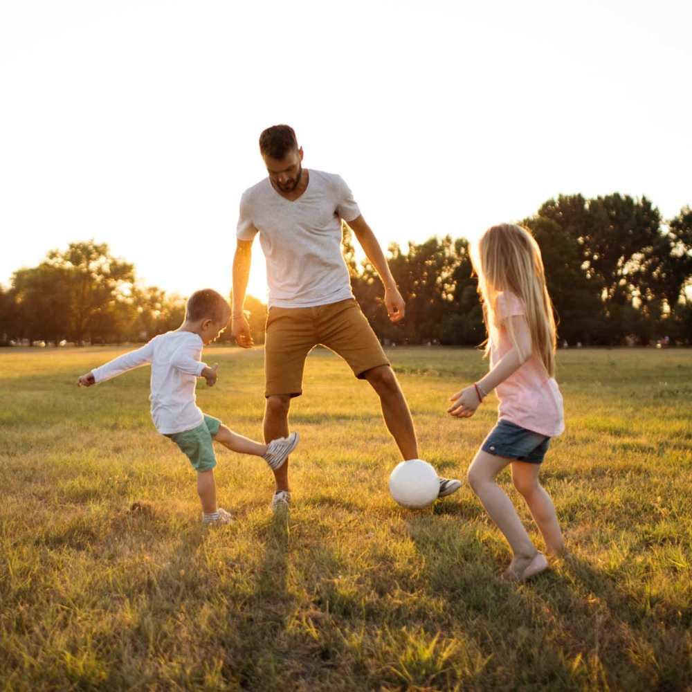Father playing football with children at Casa Madrid in Cypress, California