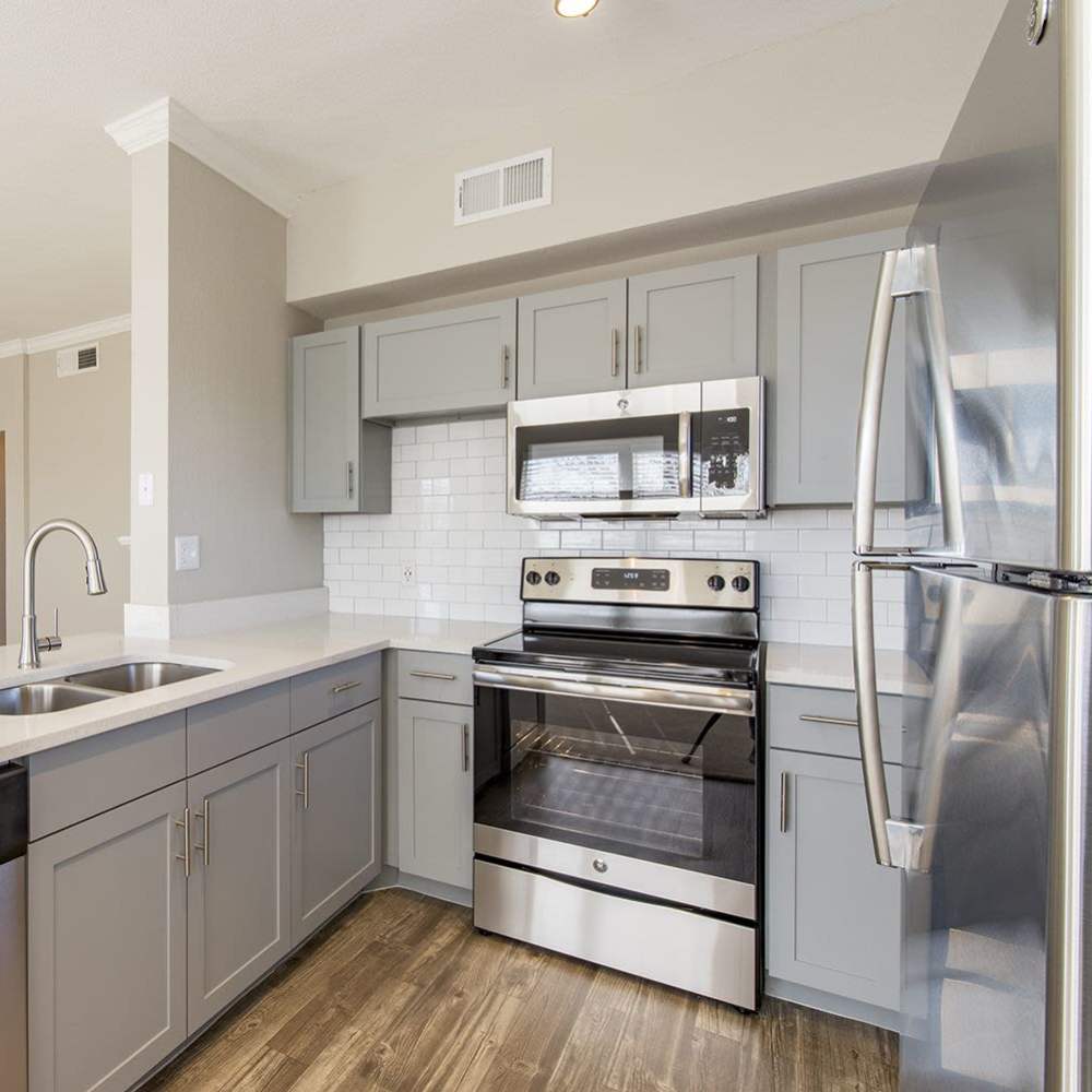 Kitchen with range, refrigerator and stainless-steel appliances at The Brighton in Houston, Texas