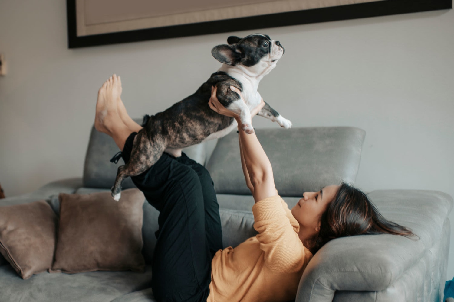 Woman holding her dog up above her on the couch at Reserve at South Creek in Englewood, Colorado