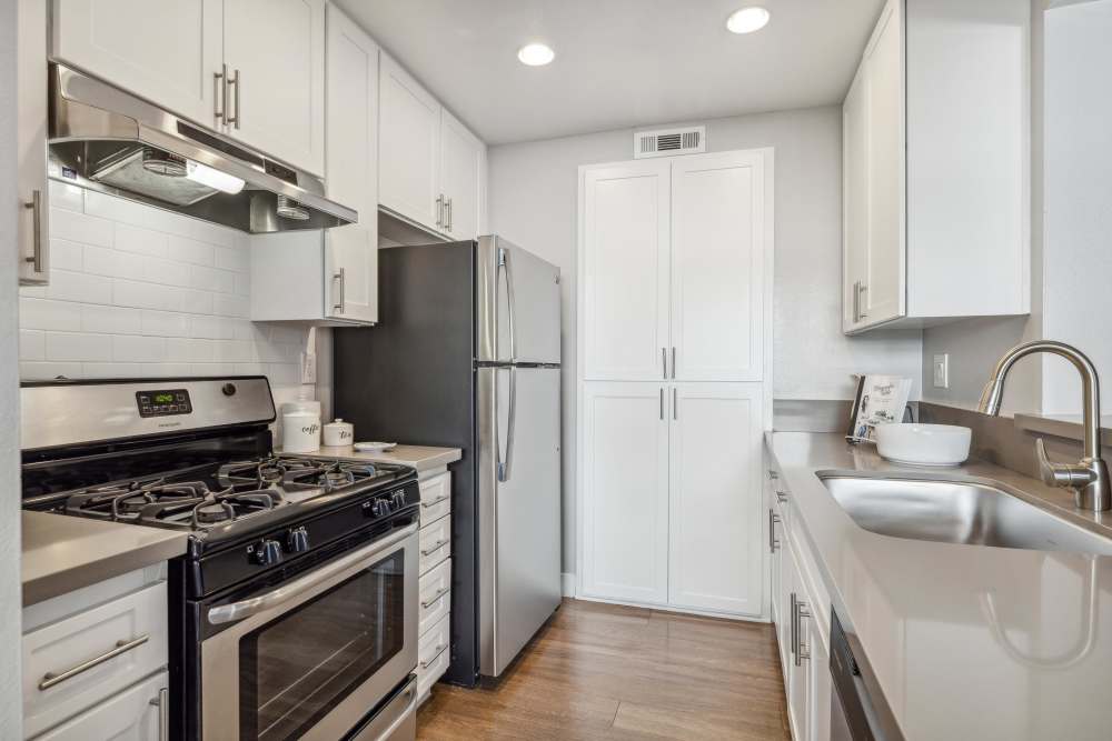 Modern kitchen with stainless-steel appliances at Portofino Townhomes in Wilmington, California