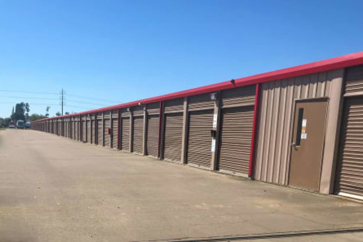Outdoor drive-up units with brown doors at Storage Star Tomball in Tomball, Texas