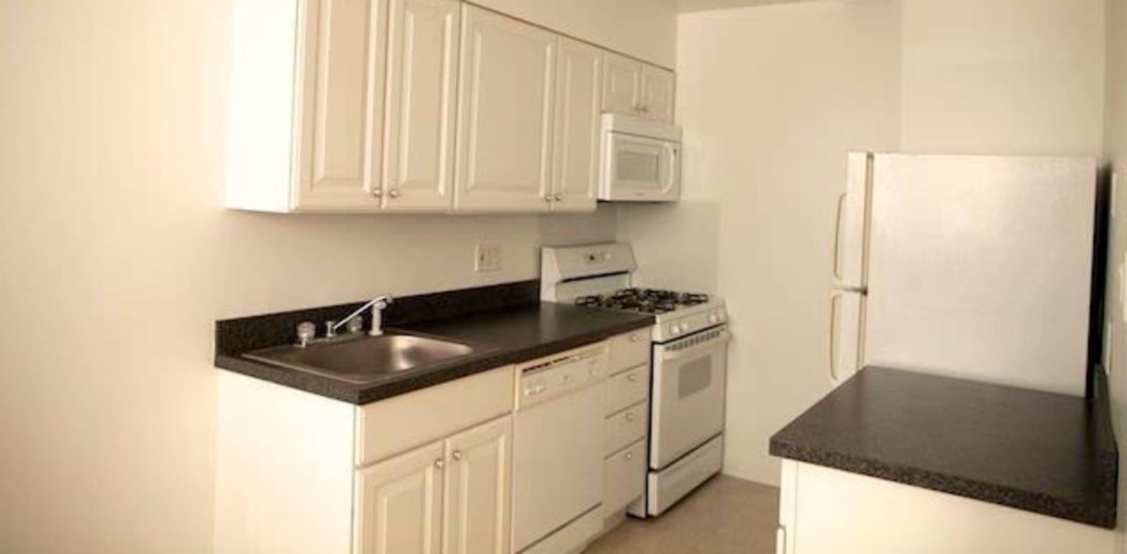 White kitchen cabinets with nice black countertops at Marina Park Apartments in Collingswood, New Jersey