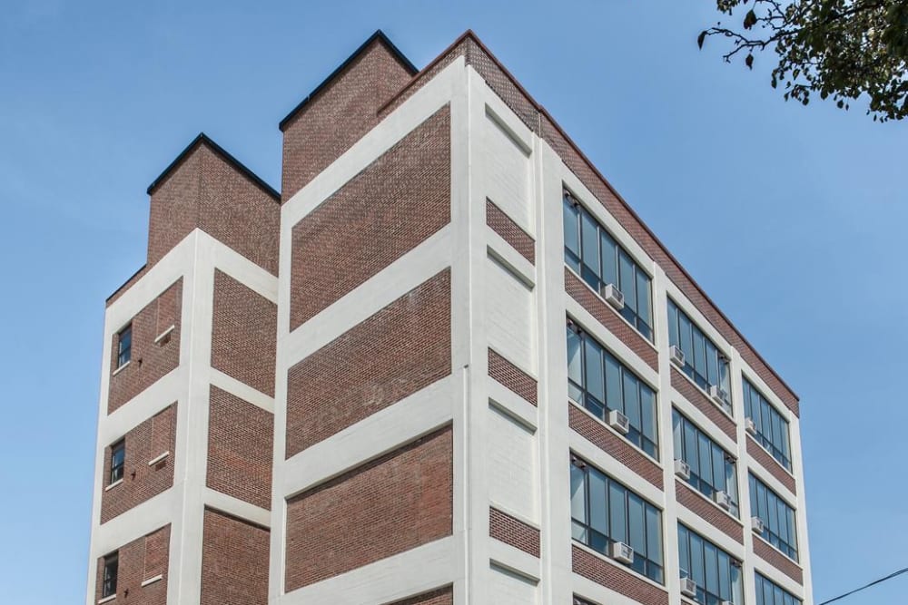 Brick building with large windows and cars at Brush Factory Lofts in Philadelphia, Pennsylvania