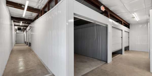A man holding a box near the storage units at Storage Hub - Broadway in San Antonio, Texas