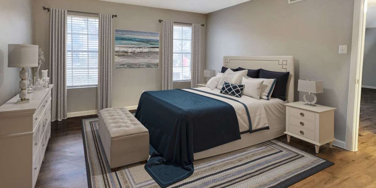 Spacious bedroom with large comfortable bed, wood-style flooring, and plush carpet at Costa Mesa Apartments in Houston, Texas 