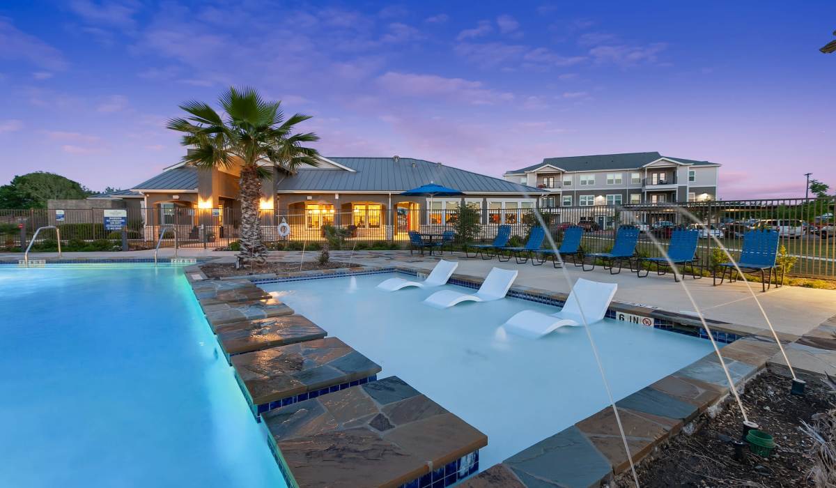 Large swimming pool with seating lounge at Canyon House in New Braunfels, Texas