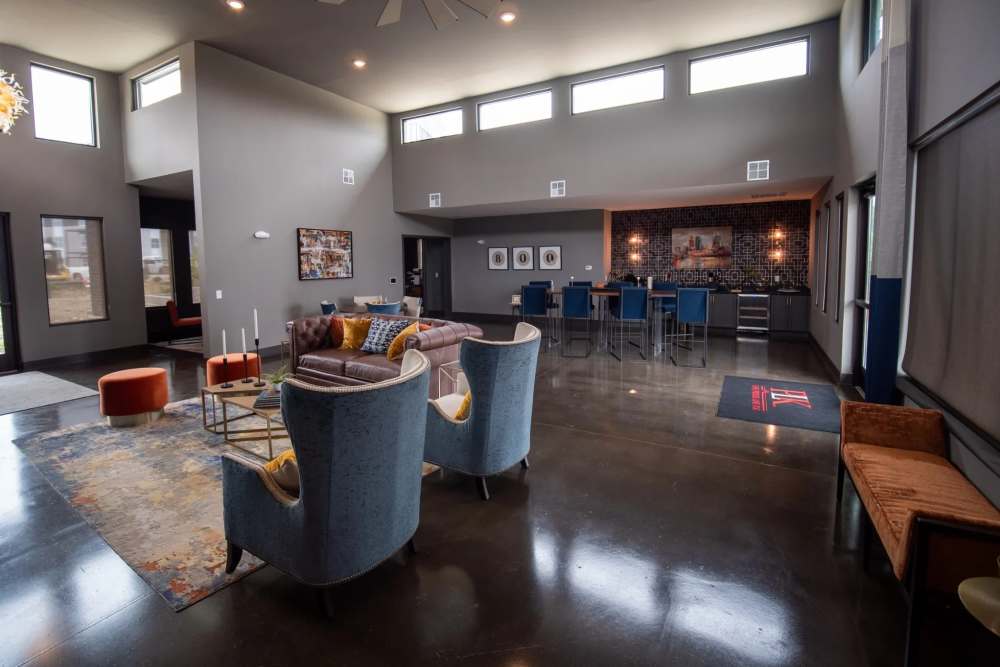 Spacious clubhouse at Elevation 800 with high ceilings, modern lounge, seating, bar area, and large windows bringing in natural light.