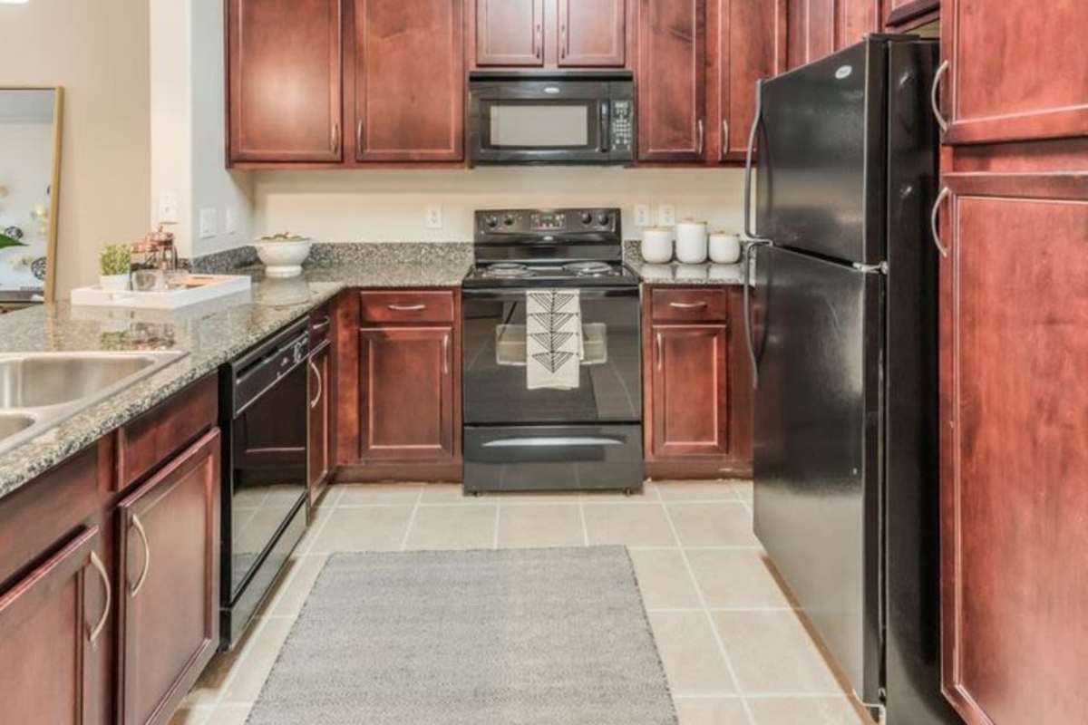 Modern kitchen with wooden cabinets at Villas At Bunker Hill, Houston, Texas