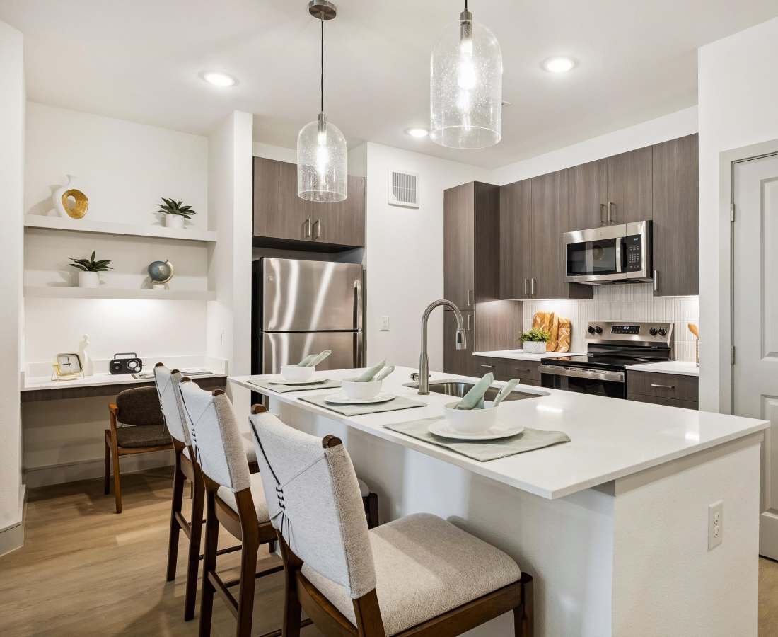 Kitchen island with seating and modern appliances at Dakota at Hillcroft in Houston, Texas