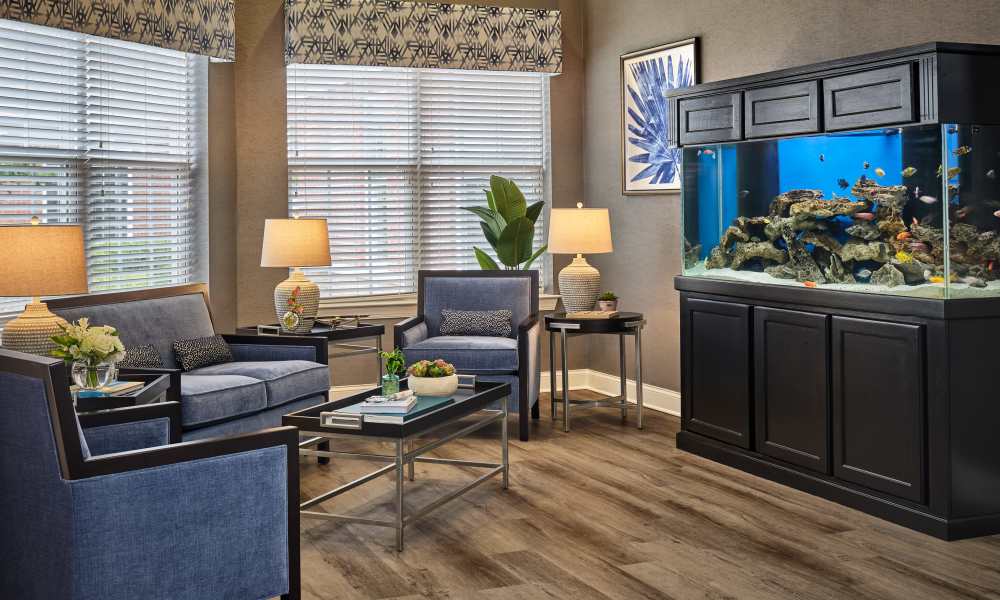 Resident lounge with seating and aquarium at Waltonwood Cotswold in Charlotte, North Carolina  