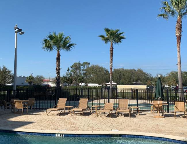 A view of the swimming pool with lounge chairs at Journet Place in Port Richey, Florida