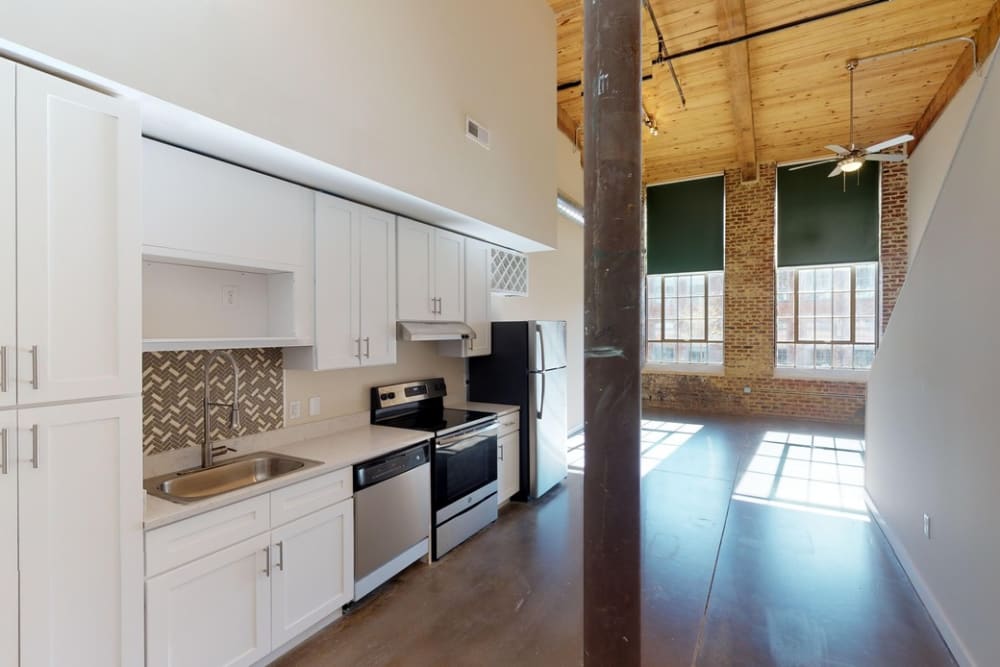 An apartment kitchen with wood flooring at Bellevue Mill in Hillsborough, North Carolina