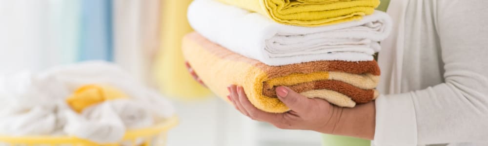 Caregiver with freshly folded towels at Wellington Place at Hartford in Hartford, Wisconsin