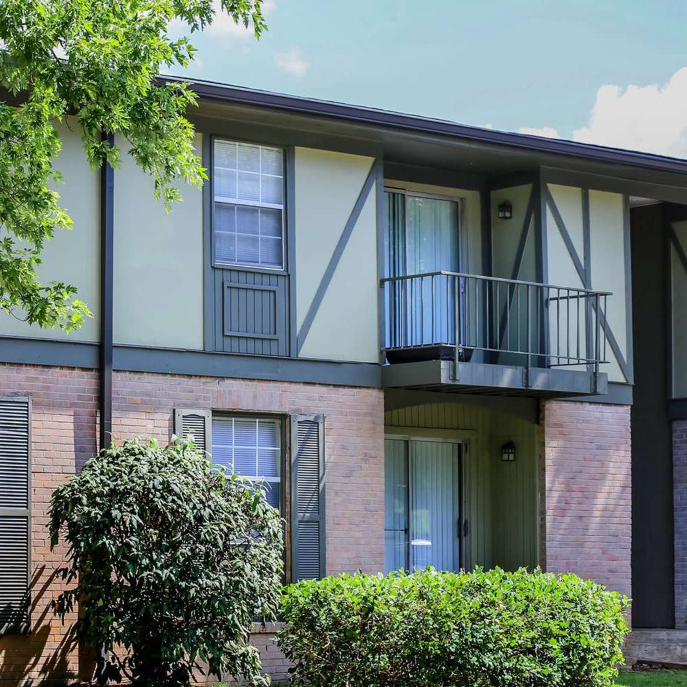 An apartment building featuring windows with shutters and a balcony at Dominion House Apartments in Nashville, Tennessee