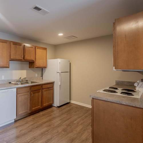 Kitchen shoing white appliances and wood-style flooring and cabinets at Kershaw Greene III in Athens, Ohio