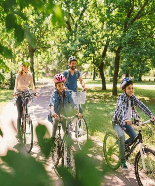 Resident family riding bicycles at park near Luxe Villas in Brentwood, California