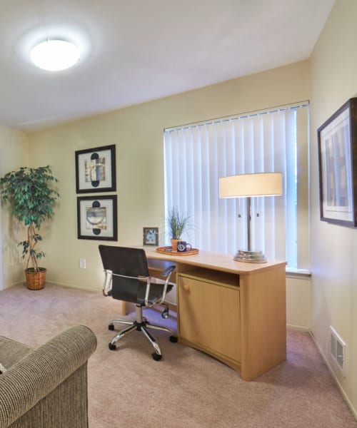 Home office with a desk and sofa at Kensington Manor Apartments in Farmington, Michigan