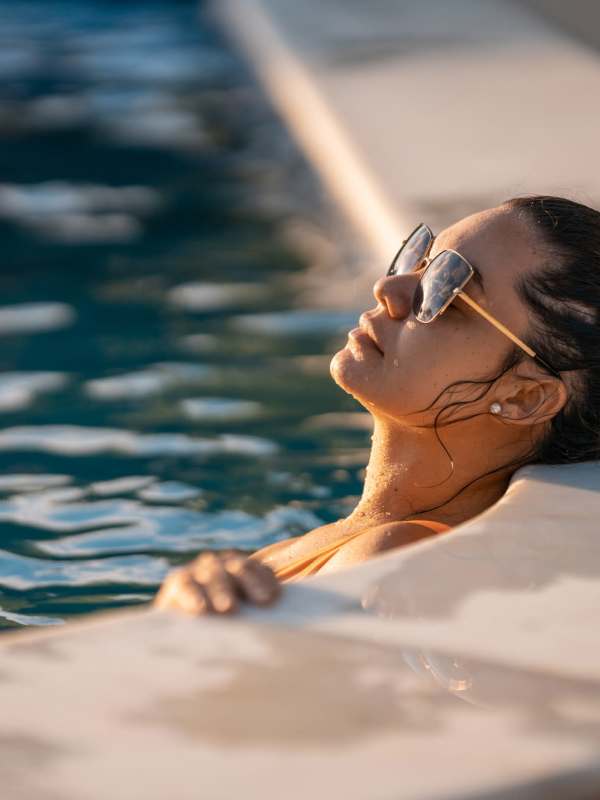 A resident relaxes in the pool at Summercrest Burleson Apartments, Burleson, Texas