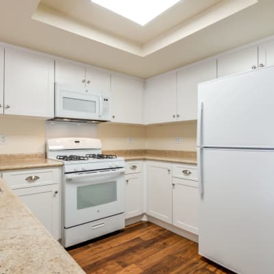 White cabinets and wood flooring in a kitchen at Stuart Mesa in Oceanside, California