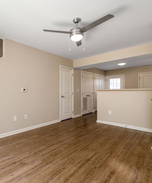 Well-lit living room with celling fan and lvt flooring at Labelle Greene III in Wheeling, West Virginia