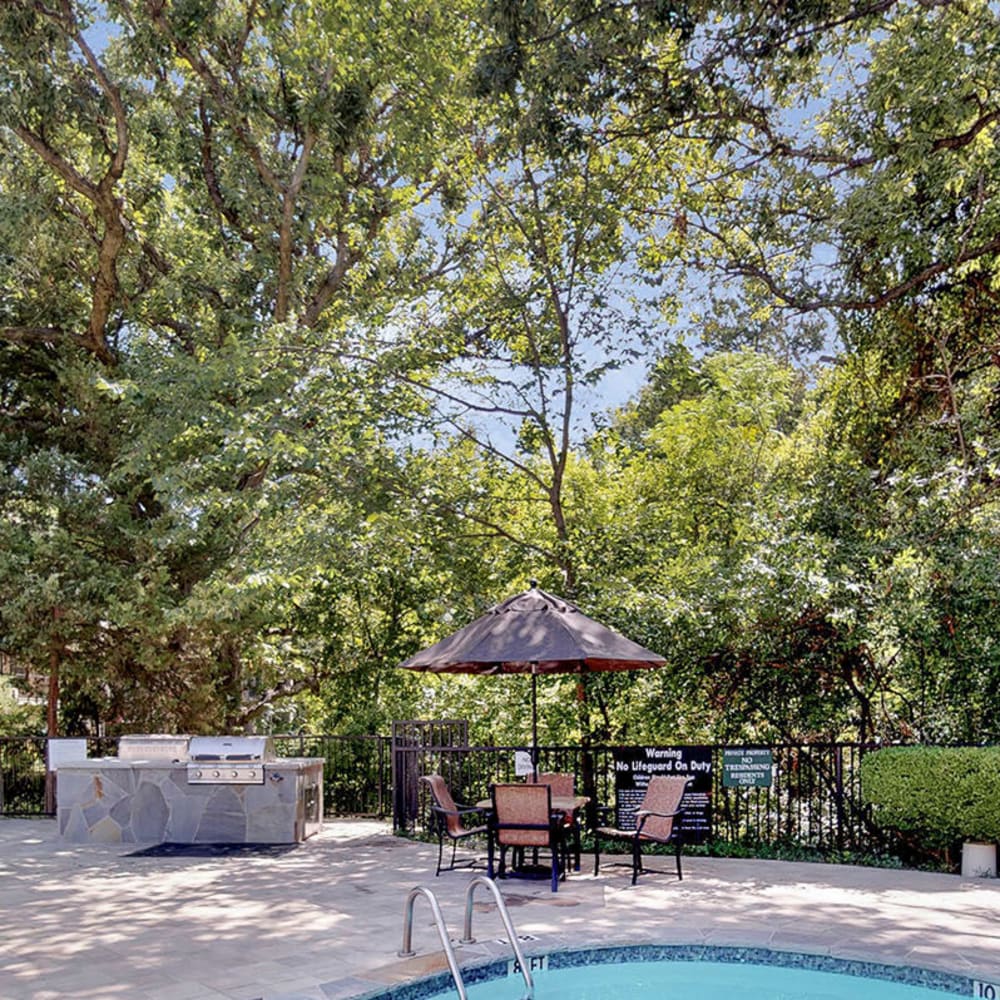 Barbecue area with gas grills near the pool at Oaks White Rock in Dallas, Texas