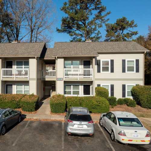 Two-story apartment building with balconies, landscaped greenery, and parking lot in front at Pleasant View Apartments in Charlotte, North Carolina